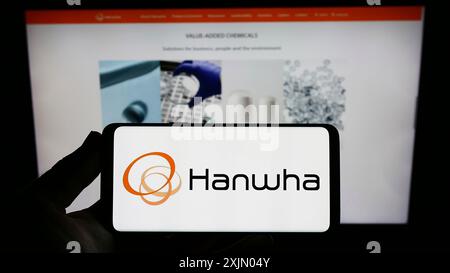 Stuttgart, Allemagne, 12 25 2022 : personne tenant un smartphone avec le logo de la société sud-coréenne Hanwha Group sur l'écran devant le site Web. Concentrez-vous sur Banque D'Images