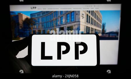 Stuttgart, Allemagne, 12 25 2022 : personne tenant un smartphone avec le logo de la société polonaise de vente au détail de vêtements LPP S.A. sur l'écran devant le site Web. Mise au point Banque D'Images