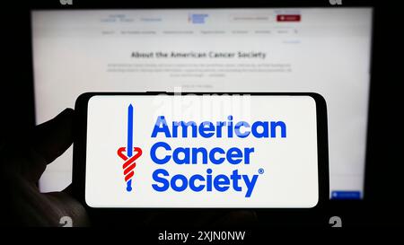 Stuttgart, Allemagne, 01-14-2023 : personne tenant un smartphone avec le logo de l'organisation American cancer Society (ACS) sur l'écran devant le site Web. Banque D'Images