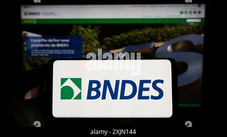 Stuttgart, Allemagne, 01-27-2023, personne tenant un smartphone avec le logo de la banque de développement brésilienne BNDES sur l'écran devant le site Web. Concentrez-vous sur le téléphone Banque D'Images