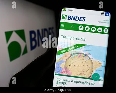 Stuttgart, Allemagne, 01-27-2023, personne tenant un smartphone avec la page web de la banque de développement brésilienne BNDES sur l'écran devant le logo. Concentrez-vous sur Banque D'Images