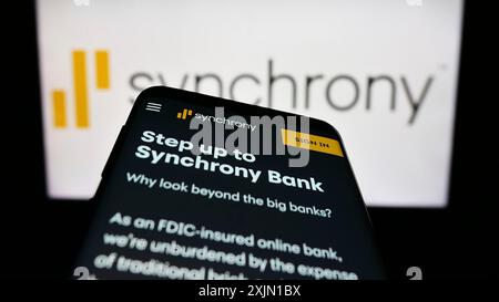 Stuttgart, Allemagne, 01-13-2023 : smartphone avec la page Web de la société américaine de services financiers Synchrony Bank sur l'écran devant le logo de l'entreprise. Concentrez-vous sur Banque D'Images
