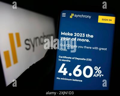 Stuttgart, Allemagne, 01-13-2023 : personne tenant un smartphone avec le site Web de la société américaine de services financiers Synchrony Bank sur l'écran avec logo. Concentrez-vous sur Banque D'Images
