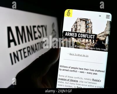 Stuttgart, Allemagne, 01-16-2023 : personne tenant un smartphone avec la page web de l'organisation de défense des droits humains Amnesty International sur l'écran avec le logo. Mise au point Banque D'Images