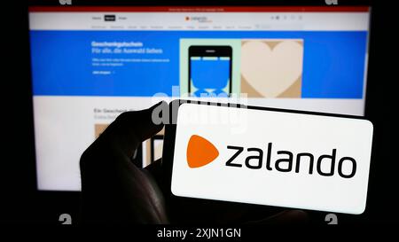 Stuttgart, Allemagne, 01-16-2023 : personne tenant un smartphone avec le logo de la société allemande de commerce électronique Zalando se sur l'écran devant le site Web. Concentrez-vous sur Banque D'Images