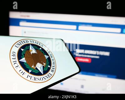 Stuttgart, Allemagne, 01-22-2023 : téléphone portable avec sceau de l'American Office of personnel Management (OPM) sur l'écran devant le site Web. Concentrez-vous sur Banque D'Images
