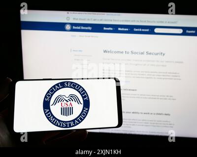 Stuttgart, Allemagne, 01-22-2023 : personne tenant un smartphone avec le sceau de l'US social Security Administration (SSA) sur l'écran devant le site Web. Mise au point Banque D'Images