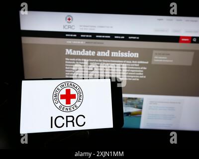 Stuttgart, Allemagne, 01-21-2023 : personne tenant un smartphone avec le logo du Comité international de la Croix-Rouge (CICR) sur l'écran devant le site Web. Banque D'Images