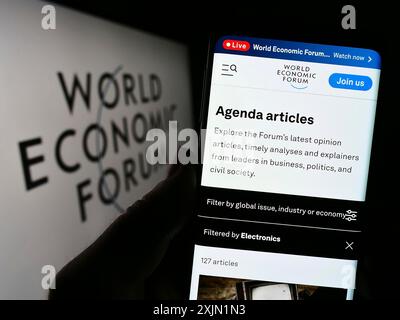 Stuttgart, Allemagne, 01-21-2023 : personne tenant un téléphone portable avec la page web de l'organisation World Economic Forum (WEF) sur l'écran devant le logo. Concentrez-vous sur Banque D'Images