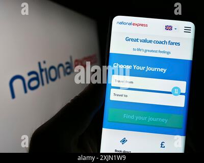 Stuttgart, Allemagne, 01-27-2023, personne tenant un smartphone avec la page web de la société britannique National Express Group plc (NX) sur l'écran avec le logo. Mise au point Banque D'Images