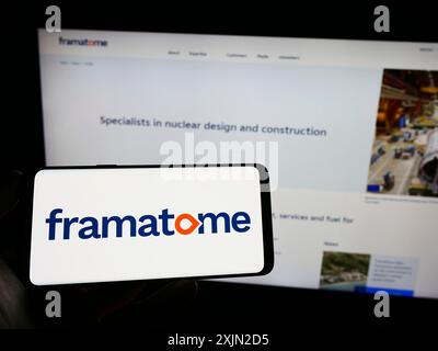 Stuttgart, Allemagne, 01-29-2023, personne tenant un téléphone portable avec le logo de la société de réacteur nucléaire Framatome SAS sur l'écran en face de la page Web de l'entreprise. Banque D'Images