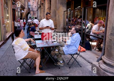 Bologne, Italie. Serveur prenant commande de nourriture devant le restaurant dans la rue latérale Banque D'Images