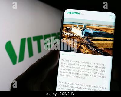 Stuttgart, Allemagne, 03-08-2023 : personne tenant un smartphone avec la page web de la société de négoce de marchandises Viterra Limited sur l'écran devant le logo. Mise au point Banque D'Images