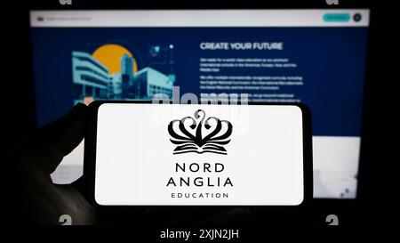 Stuttgart, Allemagne, 03-08-2023 : personne tenant un smartphone avec le logo de l'entreprise scolaire Nord Anglia Education Limited sur l'écran devant le site Web. Banque D'Images