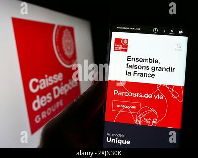 Stuttgart, Allemagne, 03-12-2013 2023 : personne tenant un smartphone avec la page web de la Caisse des dépôts et consignations (CDC) sur l'écran devant le logo. Mise au point Banque D'Images