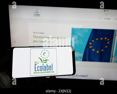 Stuttgart, Allemagne, 03-12-2023 : personne tenant un téléphone portable avec le logo de la certification environnementale eu Ecolabel sur l'écran en face de la page web. Concentrez-vous sur Banque D'Images