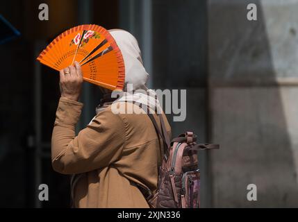 Malaga, Espagne. 19 juillet 2024. Une femme est vue utilisant un ventilateur pour se protéger du soleil pendant la première canicule espagnole de l'été. L’Agence d’État météorologique espagnole a émis un avertissement orange pour plusieurs villes du pays, en raison de la combinaison de températures élevées, de poussière et de brume provenant d’Afrique du Nord qui feront monter les températures au-dessus de 40 degrés. (Photo de Jesus Merida/SOPA images/SIPA USA) crédit : SIPA USA/Alamy Live News Banque D'Images