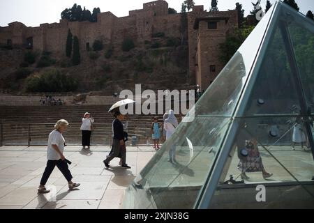 Malaga, Espagne. 19 juillet 2024. Un couple de touristes vus à l'aide d'un parapluie pour se protéger du soleil alors qu'ils marchent dans la rue Alcazabilla pendant la première vague de chaleur de l'Espagne de l'été. L’Agence d’État météorologique espagnole a émis un avertissement orange pour plusieurs villes du pays, en raison de la combinaison de températures élevées, de poussière et de brume provenant d’Afrique du Nord qui feront monter les températures au-dessus de 40 degrés. (Photo de Jesus Merida/SOPA images/SIPA USA) crédit : SIPA USA/Alamy Live News Banque D'Images