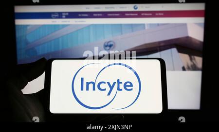 Stuttgart, Allemagne, 03-22-2023 : personne tenant un téléphone portable avec le logo de la société pharmaceutique américaine Incyte Corporation sur l'écran devant Banque D'Images
