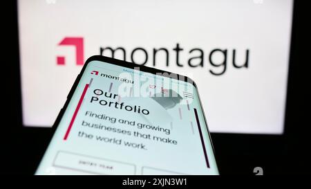 Stuttgart, Allemagne, 03-23-2023 : smartphone avec le site web de la société d'investissement Montagu Private Equity LLP sur l'écran devant le logo de l'entreprise. Mise au point Banque D'Images