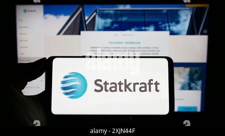 Stuttgart, Allemagne, 03-24-2023 : personne tenant un téléphone portable avec le logo de la compagnie hydroélectrique norvégienne Statkraft COMME sur l'écran devant l'entreprise Banque D'Images