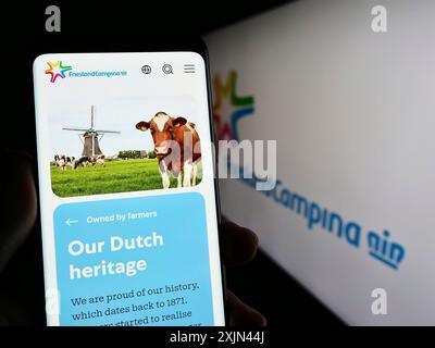 Stuttgart, Allemagne, 03-25-2023, personne tenant un smartphone avec la page web de la société Koninklijke FrieslandCampina N.V. sur l'écran devant le logo. Banque D'Images