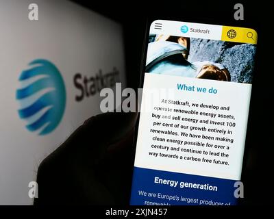 Stuttgart, Allemagne, 03-24-2023 : personne tenant un smartphone avec le site web de la compagnie hydroélectrique norvégienne Statkraft COMME sur l'écran devant le logo. Mise au point Banque D'Images