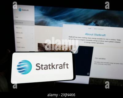 Stuttgart, Allemagne, 03-24-2023 : personne tenant un smartphone avec le logo de la société hydroélectrique norvégienne Statkraft COMME sur l'écran devant le site Web. Mise au point Banque D'Images