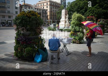 Malaga, Espagne. 19 juillet 2024. Un vendeur de rue est vu assis à l'ombre dans une rue pendant la première canicule espagnole de l'été. L’Agence d’État météorologique espagnole a émis un avertissement orange pour plusieurs villes du pays, en raison de la combinaison de températures élevées, de poussière et de brume provenant d’Afrique du Nord qui feront monter les températures au-dessus de 40 degrés. (Photo de Jesus Merida/SOPA images/SIPA USA) crédit : SIPA USA/Alamy Live News Banque D'Images