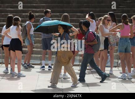 Malaga, Espagne. 19 juillet 2024. Un couple de touristes vus à l'aide d'un parapluie pour se protéger du soleil alors qu'ils marchent dans la rue Alcazabilla pendant la première vague de chaleur de l'Espagne de l'été. L’Agence d’État météorologique espagnole a émis un avertissement orange pour plusieurs villes du pays, en raison de la combinaison de températures élevées, de poussière et de brume provenant d’Afrique du Nord qui feront monter les températures au-dessus de 40 degrés. (Photo de Jesus Merida/SOPA images/SIPA USA) crédit : SIPA USA/Alamy Live News Banque D'Images