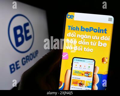 Stuttgart, Allemagne, 04-02-2023 : personne tenant un téléphone portable avec la page Web de la société technologique vietnamienne BE Group JSC sur l'écran devant le logo. Mise au point Banque D'Images