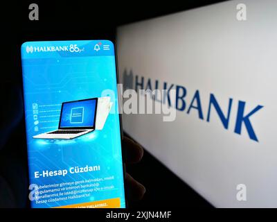 Stuttgart, Allemagne, 04-02-2023 : personne tenant un téléphone portable avec le site de la société Turkiye Halk Bankasi A.S. (Halkbank) sur l'écran avec le logo. Concentrez-vous sur Banque D'Images