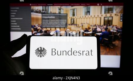 Stuttgart, Allemagne, 04-02-2023 : personne tenant un smartphone avec le sceau du corps législatif allemand Bundesrat sur l'écran devant le site. Concentrez-vous sur Banque D'Images