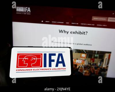 Stuttgart, Allemagne, 04-02-2023 : personne tenant un smartphone avec le logo de l'internationale Funkausstellung Berlin (IFA) sur l'écran devant le site. Banque D'Images