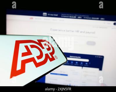 Stuttgart, Allemagne, 04 26 2023 : smartphone avec le logo de la société américaine Automatic Data Processing Inc (ADP) sur l'écran en face du site Web. Concentrez-vous sur Banque D'Images