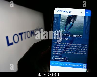 Stuttgart, Allemagne, 04-19-2023 : personne tenant un smartphone avec le site de la société italienne de jeux d'argent Lottomatica S.p.A. sur l'écran avec logo. Concentrez-vous sur Banque D'Images