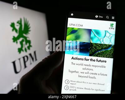 Stuttgart, Allemagne, 03-31-2023, personne tenant son téléphone portable avec le site Web de la société forestière finlandaise UPM-Kymmene Oyj sur l'écran devant le logo. Mise au point Banque D'Images