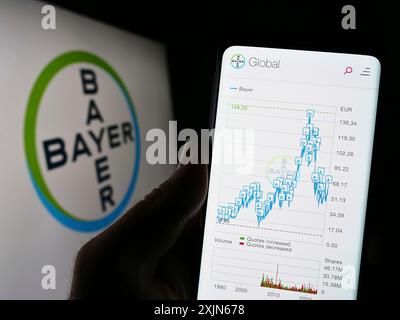 Stuttgart, Allemagne, 04-16-2023 : personne tenant un téléphone portable avec le site de la société pharmaceutique allemande Bayer AG sur l'écran devant le logo. Concentrez-vous sur Banque D'Images