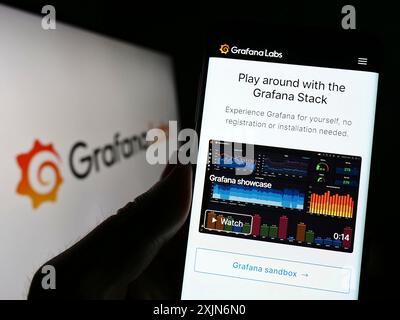 Stuttgart, Allemagne, 03-26-2023, personne tenant un smartphone avec la page Web de la société américaine de logiciels d'analyse Grafana Labs sur l'écran devant le logo. Banque D'Images