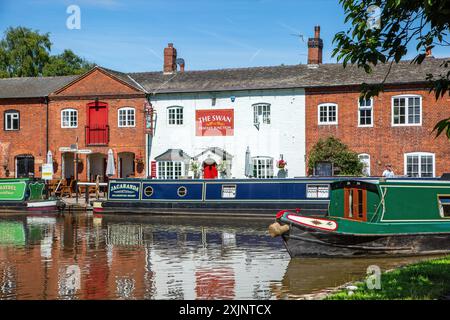 Bateau étroit quittant le canal Trent and Mersey canal à Fradley Junction Staffordshire, pour rejoindre le canal de Coventry par la maison publique Swan inn Banque D'Images