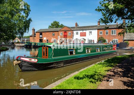 Bateau étroit quittant le canal Trent and Mersey canal à Fradley Junction Staffordshire, pour rejoindre le canal de Coventry par la maison publique Swan inn Banque D'Images