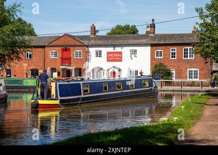 Canal Nearwboat quittant le canal Coventry à Fradley Junction Staffordshire, pour rejoindre le canal Trent et Mersey par la maison publique Swan inn Banque D'Images