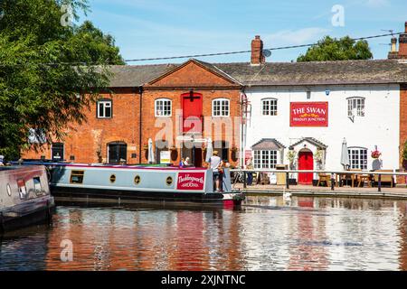 Canal Nearwboat quittant le canal Coventry à Fradley Junction Staffordshire, pour rejoindre le canal Trent et Mersey par la maison publique Swan inn Banque D'Images