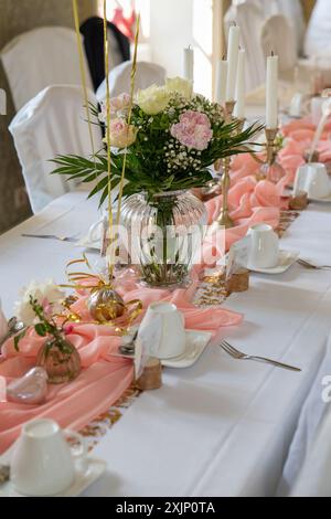 De belles fleurs décoraient la table. Des tables sont aménagées pour une fête ou une réception de mariage. cadre élégant de luxe dans le restaurant avec des bougies. Banque D'Images