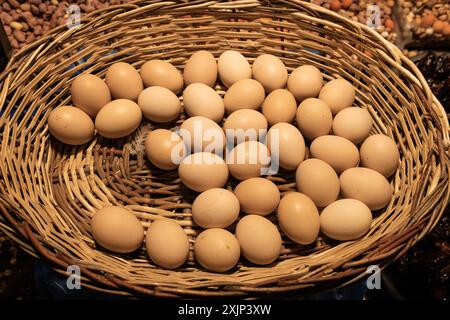 Oeufs frais de la ferme organique dans le panier de paille Banque D'Images