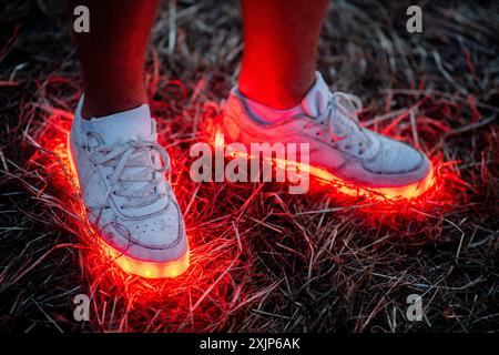 Nordholz, Allemagne. 19 juillet 2024. Un festivalier porte des chaussures lumineuses au Deichbrand Festival. Le festival en plein air avec environ 60 000 visiteurs a lieu du 18 au 21 juillet. Crédit : Hauke-Christian Dittrich/dpa/Alamy Live News Banque D'Images