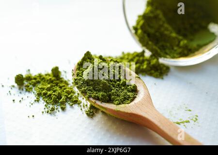 Poudre de matcha organique dans une cuillère en bois avec fond blanc Banque D'Images
