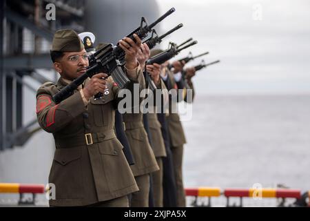 Les Marines des États-Unis affectés à la 15th Marine Expeditionary Unit et les marins affectés au navire d'assaut amphibie USS Boxer (LHD 4) effectuent un salut à la carabine lors d'une cérémonie d'enterrement en mer à bord du Boxer dans l'océan Pacifique le 17 juillet 2024. La cérémonie a eu lieu en l'honneur de Kevin Buckley, le chef d'armes principal de la marine à la retraite, le père du Sgt Gregory Buckley, le chef des opérations de communication affecté à la 15e MEU, et natif de Carthage, New York. Des éléments de la 15e MEU sont actuellement embarqués à bord du Boxer Amphibious Ready Group menant des opérations de routine dans le 3e FLE américain Banque D'Images