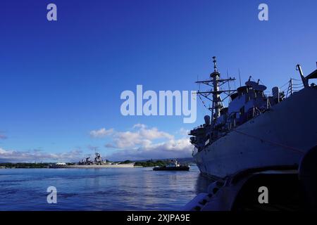 Le destroyer à missiles guidés de classe Arleigh Burke USS Hopper (DDG 70) passe devant le cuirassé USS Missouri Memorial, tout en étant remorqué vers le Dry Dock 4, Pearl Harbor Naval Shipyard and Intermediate maintenance Facility, Hawaï, le 27 juin 2024. Hopper a entré une disponibilité restreinte sélectionnée pour Drydocking qui devrait être terminée en août 2025. Pendant ce temps, les questions structurelles, mécaniques et de préservation seront abordées. PHNSY & IMF est le plus grand et le plus complet centre de réparation et de maintenance de flotte entre la côte ouest des États-Unis et l'extrême-Orient et fournit un système capable, prêt et 'Fit Banque D'Images