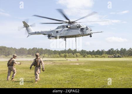 Les Marines américains avec le 2nd distribution support Battalion, combat Logistics Regiment 2, 2nd Marine Logistics Group, quittent la zone de levage lorsque le faisceau lourd attaché est déplacé pendant les opérations de l'équipe de soutien d'hélicoptère à Tactical Landing zone Condor sur Camp Lejeune, Caroline du Nord, le 18 juillet 2024. Le 2e ORD a mené la formation pour préparer les Marines à gérer les activités dans les zones de débarquement ; faciliter le ramassage, le déplacement et l'atterrissage des troupes, de l'équipement et des fournitures montés en hélicoptère. (Photo du corps des Marines des États-Unis par le caporal Franco Lewis) Banque D'Images